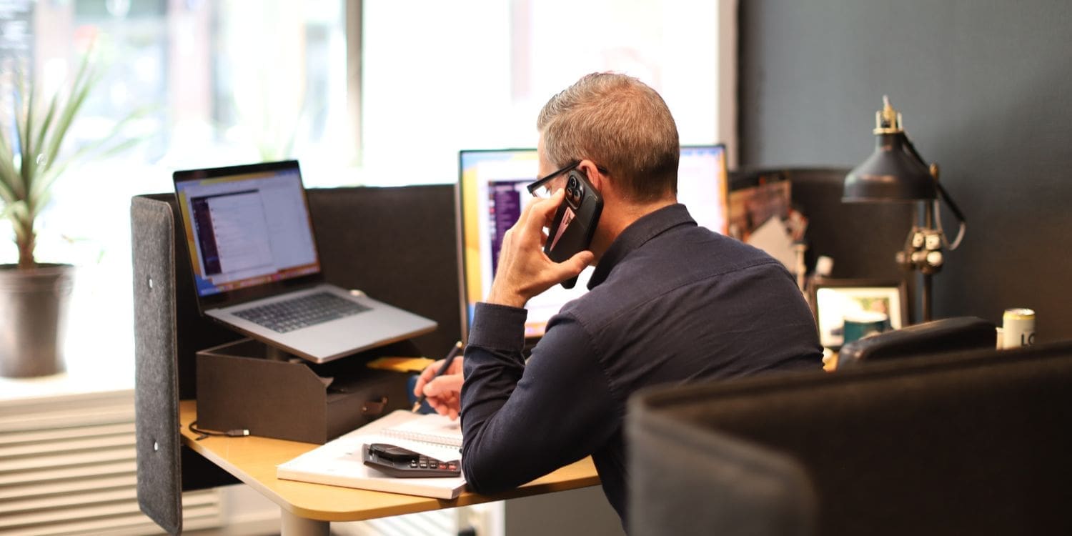 Effektiv datapresentation: VD Peter pratar i telefon vid sitt skrivbord på webbyråns kontor i Karlstad